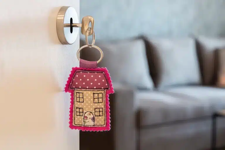 A house-shaped plushie keychain hanging from a door lock, an example of how creative branded free gifts can build emotional connection during customer engagement.