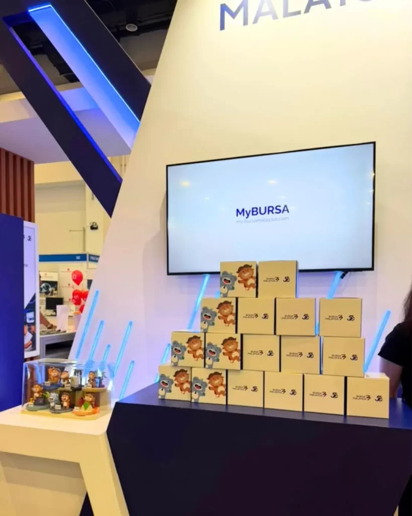 Bursa Malaysia anniversary figurines and packaging displayed for event redemption.